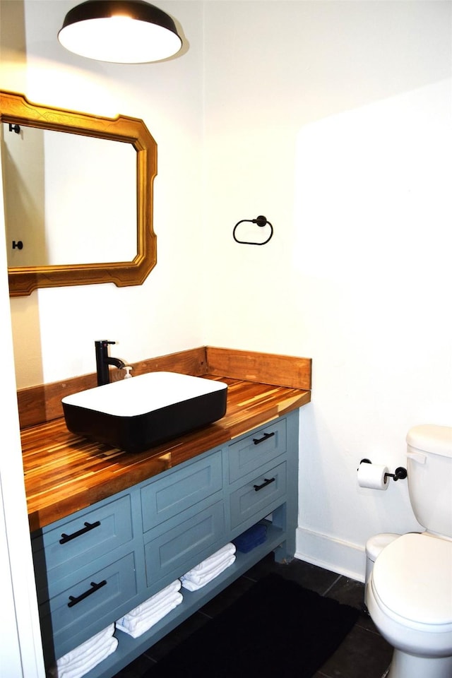 bathroom with vanity, tile patterned flooring, and toilet