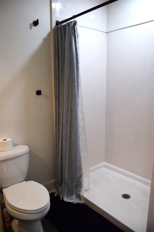 bathroom featuring toilet and a shower with shower curtain