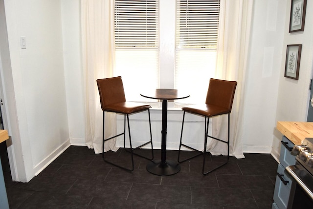 dining space with dark tile patterned flooring