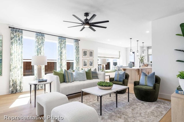 living room with ceiling fan and light hardwood / wood-style flooring