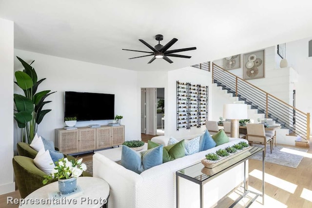 living room featuring wood-type flooring and ceiling fan