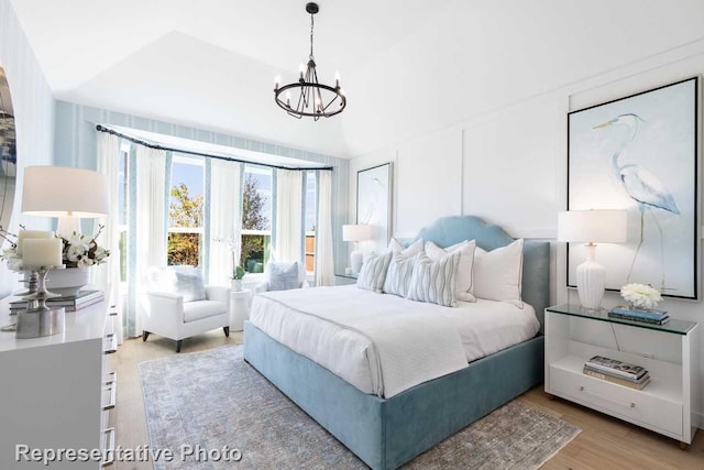 bedroom with an inviting chandelier and light wood-type flooring