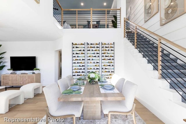 dining room featuring light hardwood / wood-style floors and a high ceiling