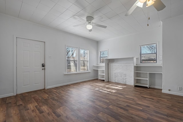 unfurnished living room with ceiling fan, ornamental molding, and dark hardwood / wood-style floors