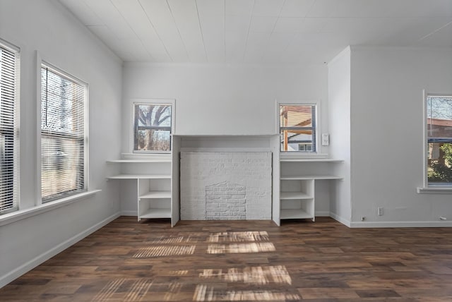 unfurnished living room featuring dark hardwood / wood-style flooring and a healthy amount of sunlight