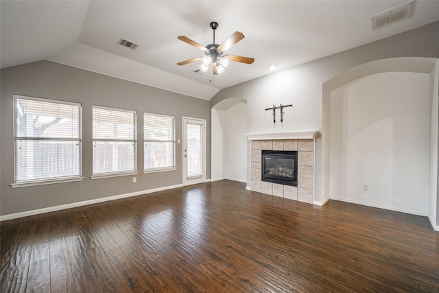 unfurnished living room featuring a tiled fireplace, dark wood-type flooring, vaulted ceiling, and ceiling fan