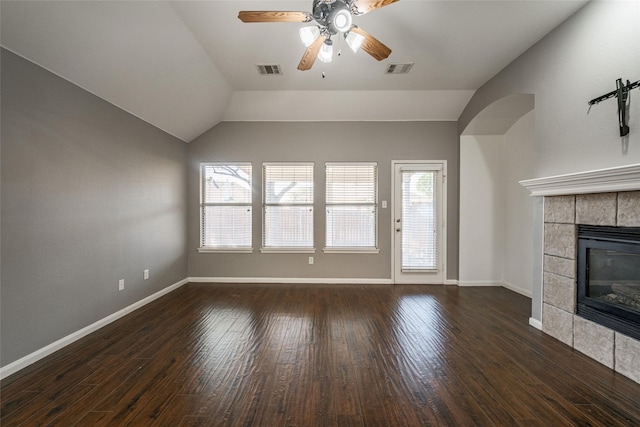 unfurnished living room with dark wood-type flooring, ceiling fan, vaulted ceiling, and a tile fireplace