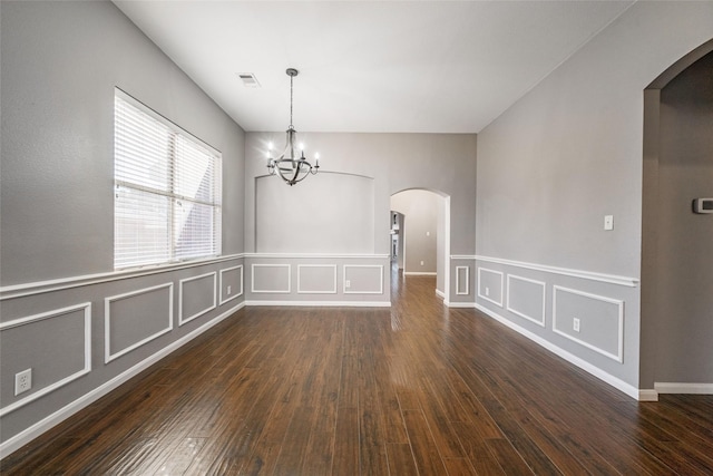 unfurnished dining area with dark wood-type flooring and a notable chandelier