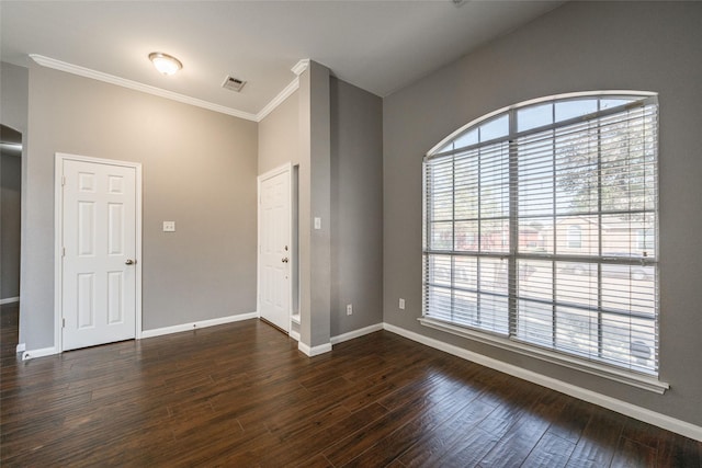 empty room featuring dark hardwood / wood-style flooring, plenty of natural light, and ornamental molding