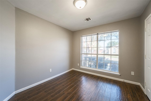 unfurnished room featuring dark hardwood / wood-style floors and a wealth of natural light