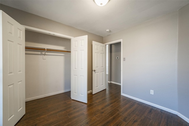 unfurnished bedroom featuring dark wood-type flooring and a closet