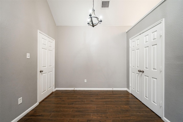 interior space with dark wood-type flooring and a chandelier