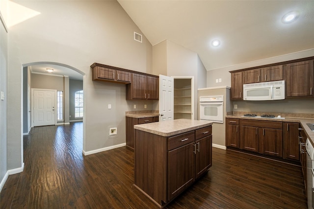 kitchen featuring dark hardwood / wood-style flooring, high vaulted ceiling, a center island, and white appliances