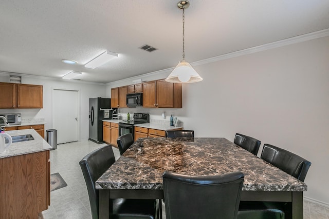 kitchen featuring light stone counters, sink, a breakfast bar area, and black appliances