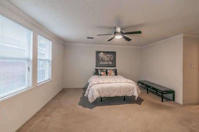 carpeted bedroom featuring ceiling fan, ornamental molding, and a textured ceiling