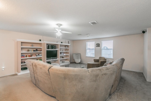 living room with ceiling fan, light colored carpet, and a textured ceiling