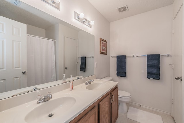 bathroom with tile patterned floors, vanity, and toilet