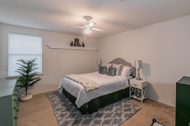 carpeted bedroom with ceiling fan and a textured ceiling