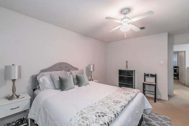 carpeted bedroom featuring ceiling fan and a textured ceiling