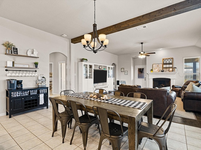 dining space with light tile patterned flooring, ceiling fan with notable chandelier, and lofted ceiling with beams