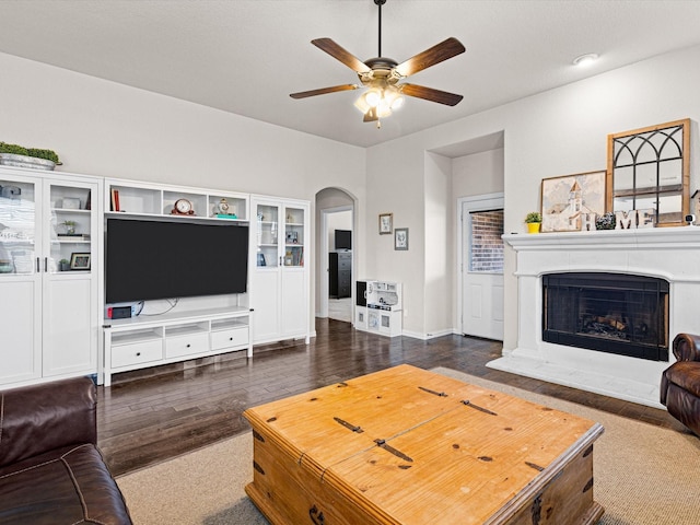 living room featuring dark wood-type flooring and ceiling fan