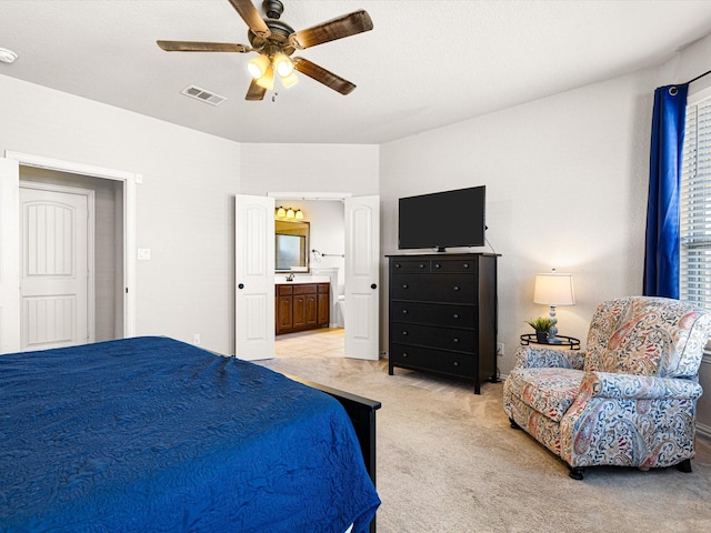 carpeted bedroom featuring ensuite bathroom and ceiling fan