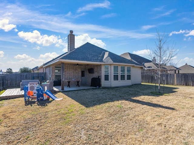 rear view of house featuring a playground, a patio, and a yard