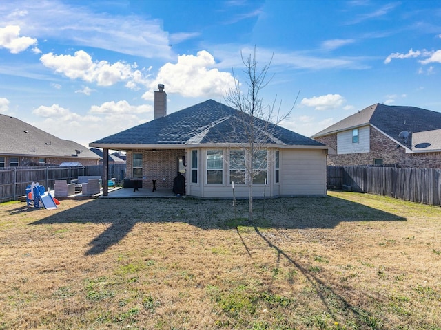 back of house featuring a patio area and a lawn