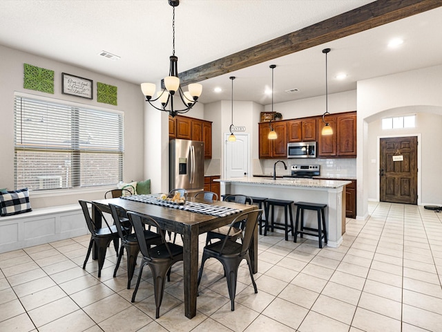 tiled dining space with sink, an inviting chandelier, and beam ceiling