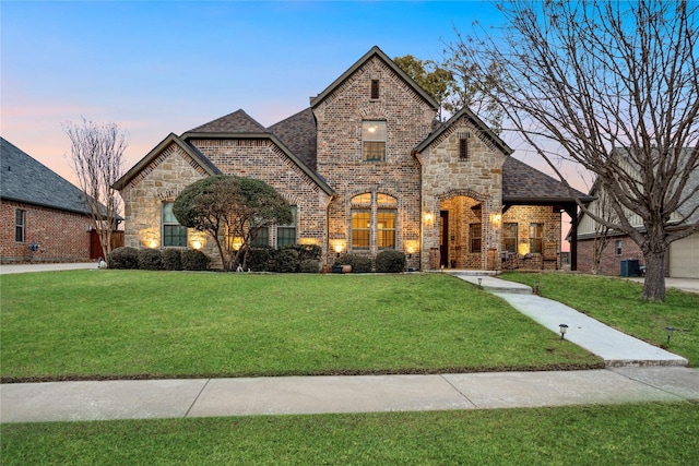 view of front of home featuring central AC and a lawn