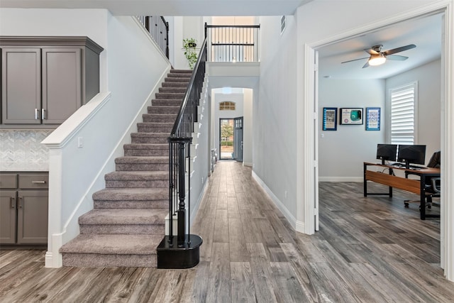 stairway featuring hardwood / wood-style flooring and ceiling fan