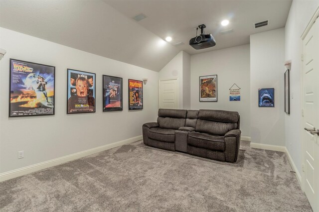 cinema room featuring vaulted ceiling and light colored carpet