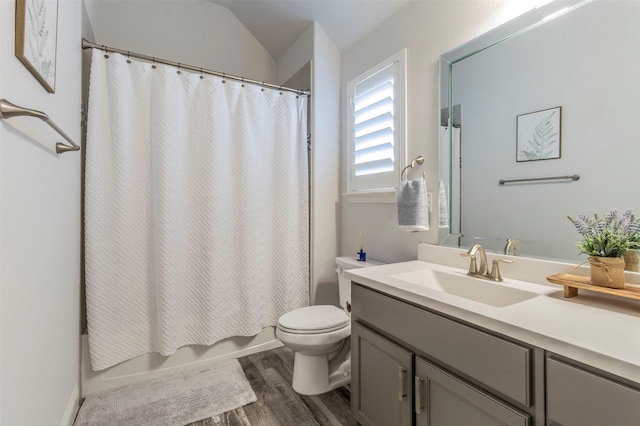 full bathroom featuring hardwood / wood-style floors, lofted ceiling, shower / bath combination with curtain, vanity, and toilet