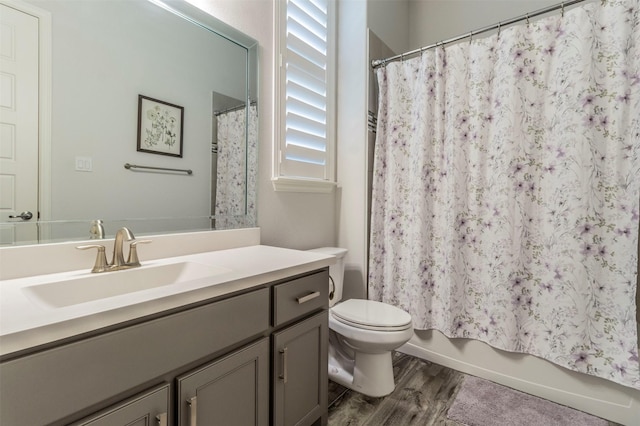 full bathroom featuring vanity, hardwood / wood-style floors, shower / bath combination with curtain, and toilet