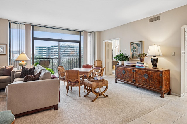 living room featuring a wall of windows and light carpet