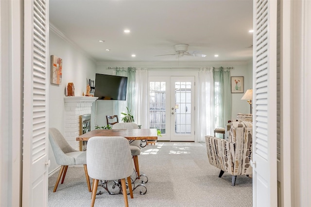 living area featuring a brick fireplace, light colored carpet, ornamental molding, and french doors