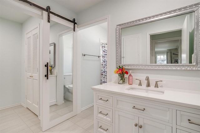 bathroom featuring vanity, tile patterned floors, and toilet