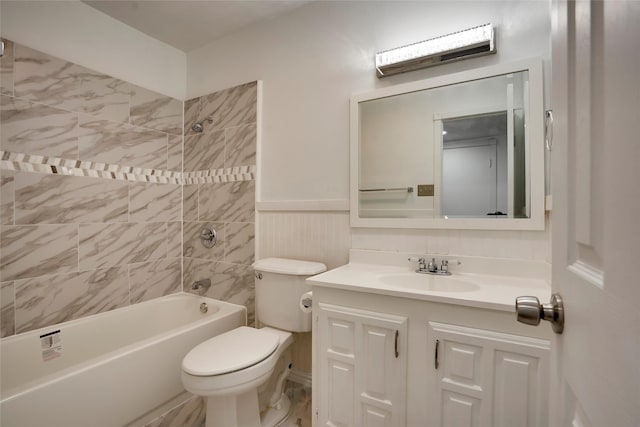 full bathroom featuring tiled shower / bath, vanity, and toilet