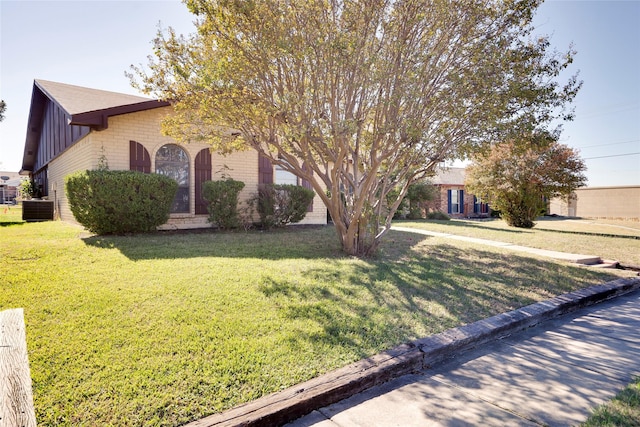 obstructed view of property featuring cooling unit and a front yard