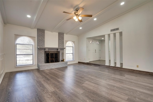 unfurnished living room featuring ceiling fan, vaulted ceiling with beams, hardwood / wood-style floors, and a fireplace