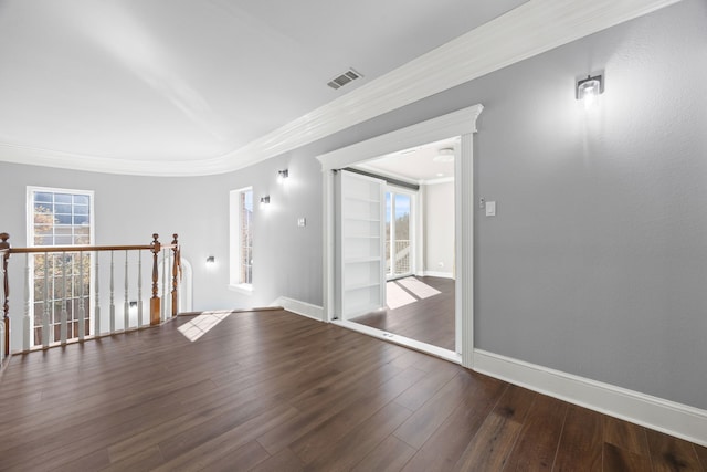 empty room with crown molding and dark hardwood / wood-style floors