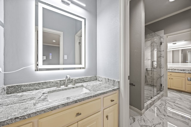 bathroom with ornamental molding, vanity, and a shower with shower door