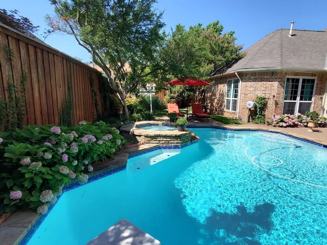 view of pool with an in ground hot tub