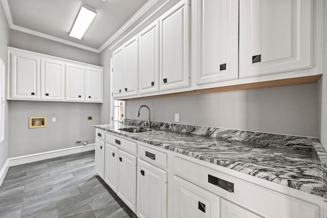 kitchen with sink, crown molding, dark stone counters, and white cabinets