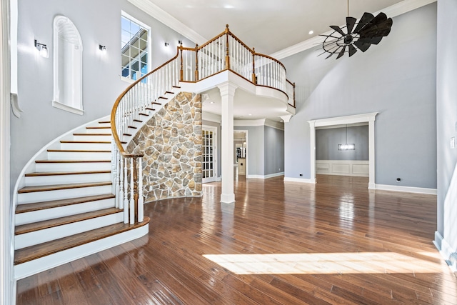 foyer with crown molding, wood-type flooring, and ornate columns