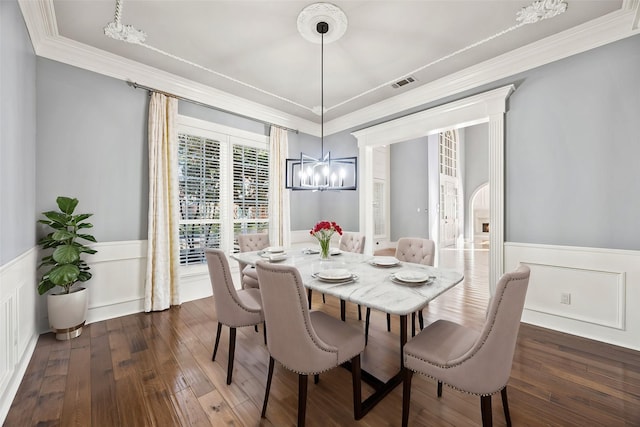 dining room with decorative columns, ornamental molding, dark hardwood / wood-style floors, and an inviting chandelier