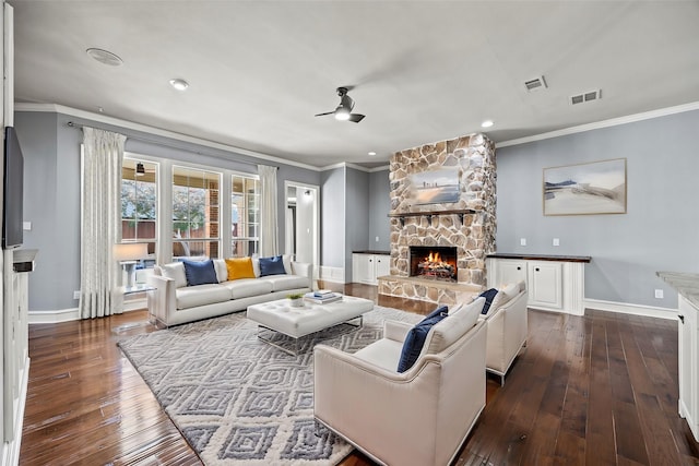 living room featuring ceiling fan, ornamental molding, a fireplace, and dark hardwood / wood-style flooring