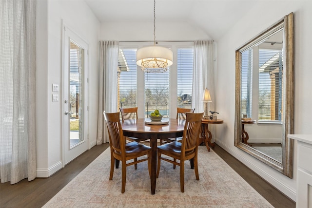 dining room featuring dark hardwood / wood-style flooring and vaulted ceiling