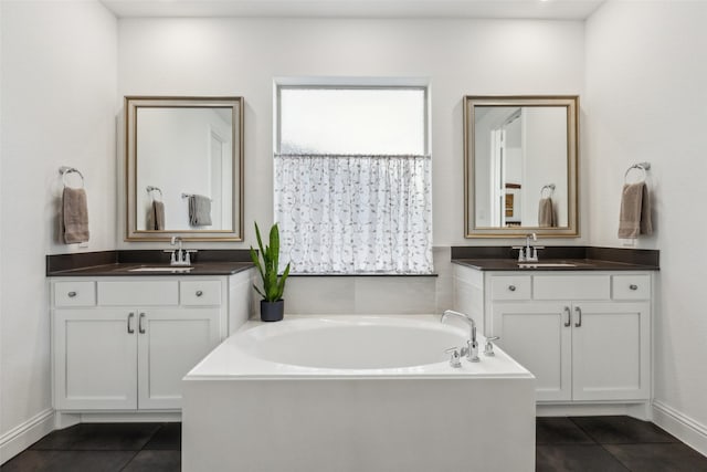 bathroom featuring vanity, a washtub, and tile patterned floors