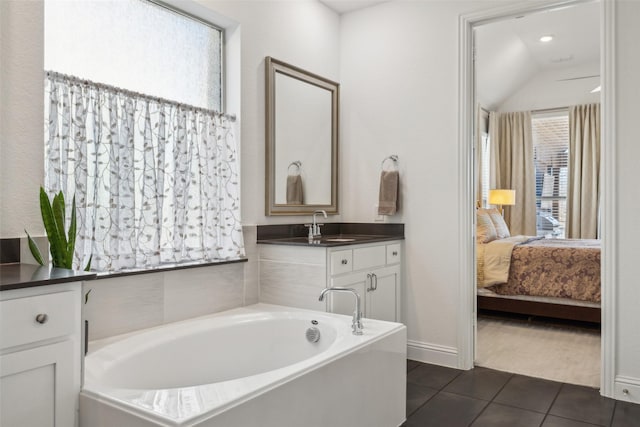 bathroom featuring tile patterned flooring, vanity, and a tub